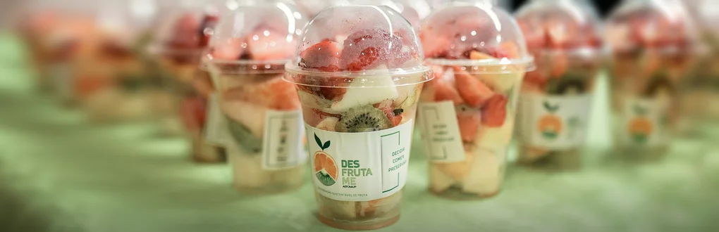 Copos de plástico com pedaços de fruta variada no interior