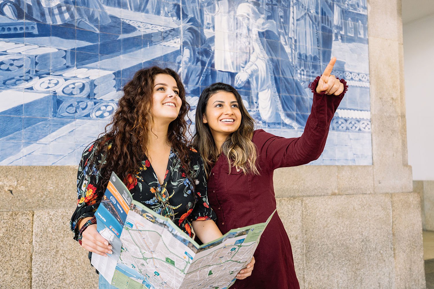 Duas estudantes internacionais a apreciarem o interior de azulejos da estação de comboios de São Bento