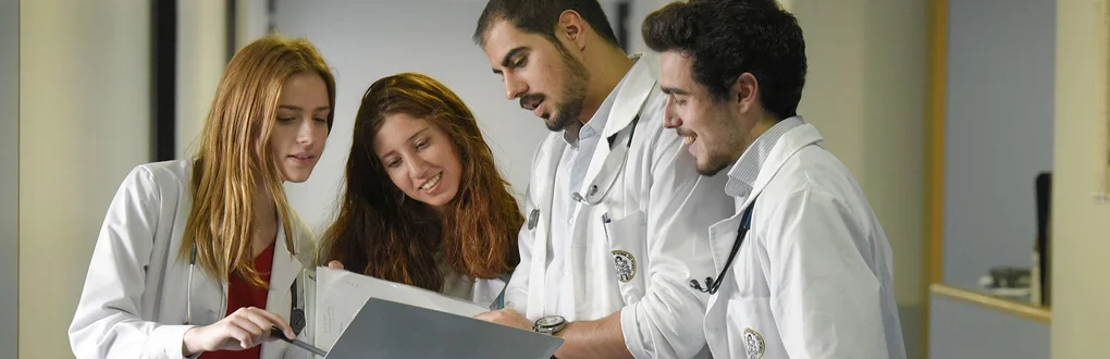 Estudantes de Medicina a trocarem impressões no corredor de um hospital