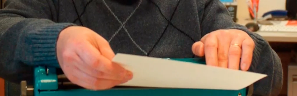 Pessoa a ler uma página impressa em braille